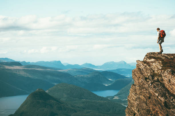 człowiek odkrywca stojący na klifie sam szczyt górski nad fiordem norwegia krajobraz travel lifestyle sukces motywacja koncepcja przygoda aktywne wakacje na świeżym powietrzu - cliff on men mountain zdjęcia i obrazy z banku zdjęć