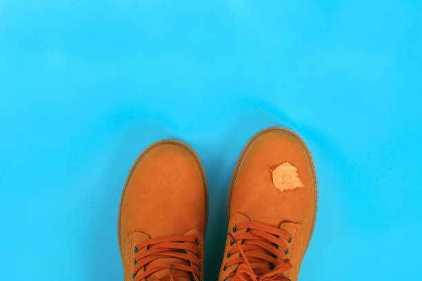 istock Orange brown mens autumn boots on a blue pastel background. Top view, copy space. 1047128492