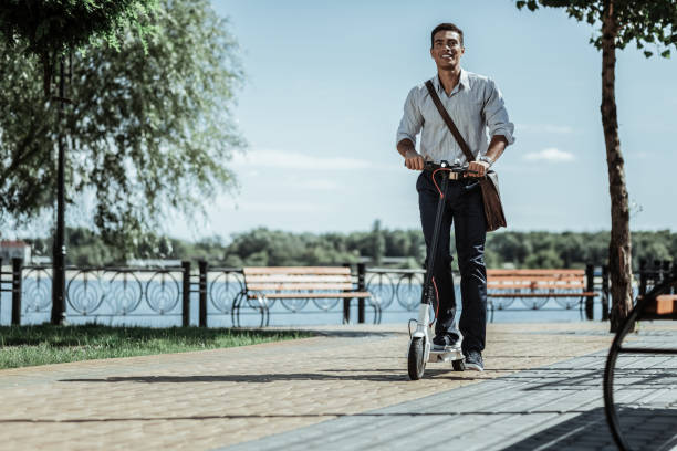 istock Pretty enthusiastic guy getting used to electric scooter 1047129488
