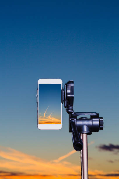 istock Smartphone on tripod capturing image of sundown in vertical mode 1047133472