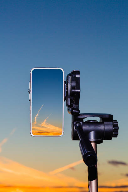 istock Smartphone on tripod capturing image of sundown in vertical mode 1047133512