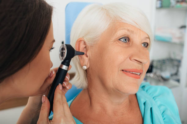istock Mature woman getting ear exam at clinic 1047136790