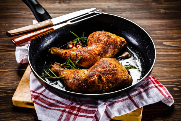 istock Fried chicken legs in pan on cutting board on wooden background 1047137362