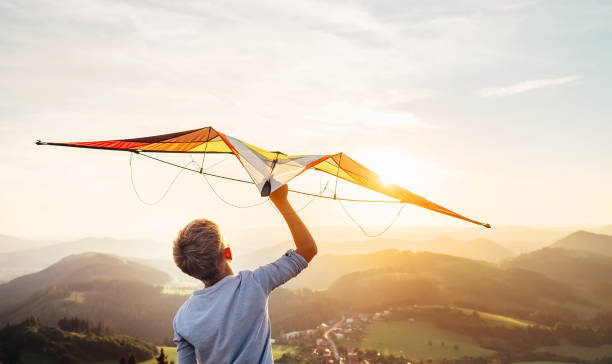 Boy takes a kite over his head. Dreams about flying