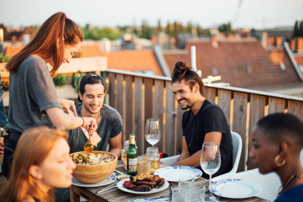 istock Multi-ethnic group of friends at barbeque party on rooftop 1047145980