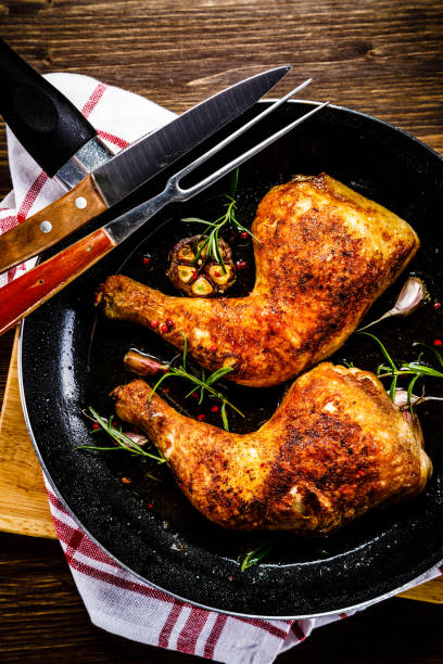 istock Fried chicken legs in pan on cutting board on wooden background 1047147238