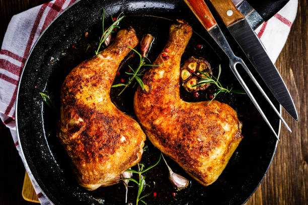 istock Fried chicken legs in pan on cutting board on wooden background 1047147564