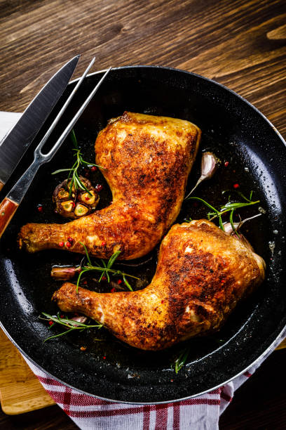 istock Fried chicken legs in pan on cutting board on wooden background 1047150962