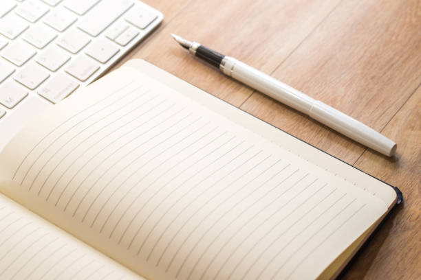 istock Office table with notepad, keyboard and fountain pen. View from above 1047154336
