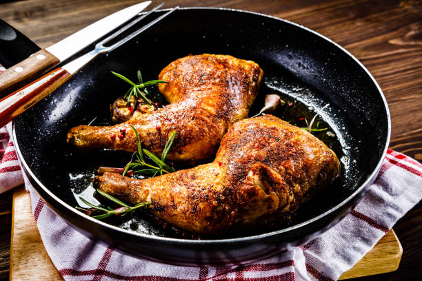 istock Fried chicken legs in pan on cutting board on wooden background 1047154346