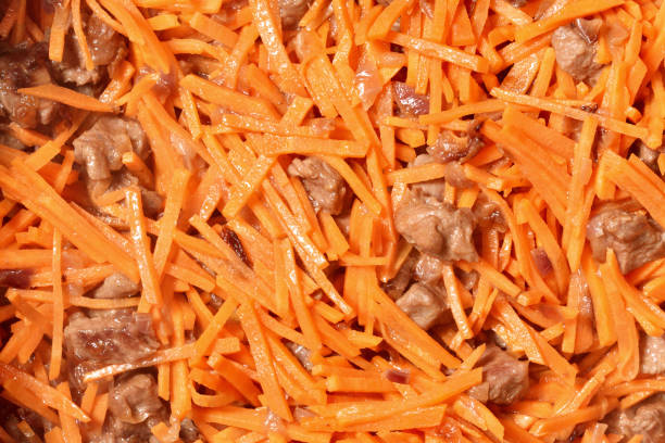 Roasting vegetables and meat in a frying pan with non-stick coating. Onion, carrots and meat
