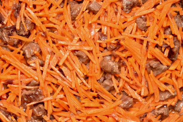 Roasting vegetables and meat in a frying pan with non-stick coating. Onion, carrots and meat