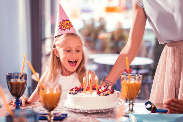 istock Happy girl feeling excited while looking at her amazing birthday cake 1047163386