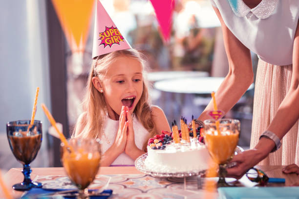 istock Impressed girl clapping her hands while looking at the beautiful cake 1047163394