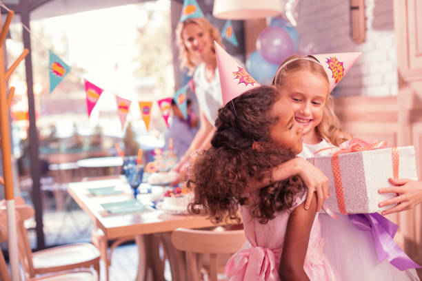 istock Adorable girl hugging her friend after getting present from her 1047163714