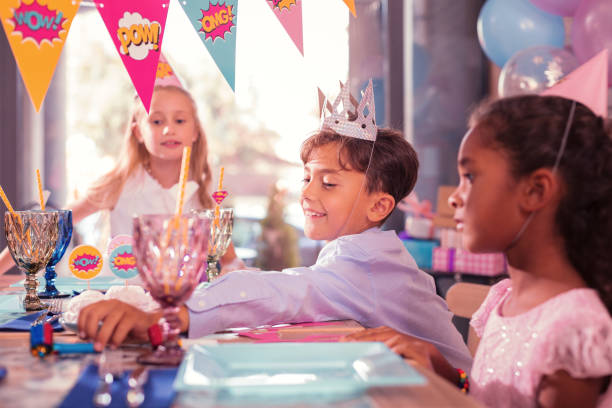 istock Funny boy smiling and taking party horn from the table 1047163778