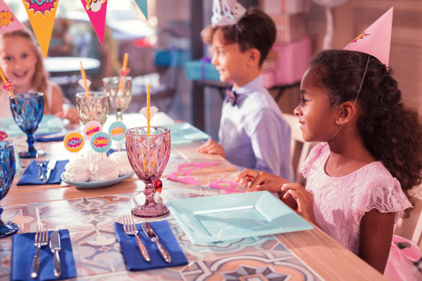istock Relaxed kids smiling while sitting at the table together 1047163812