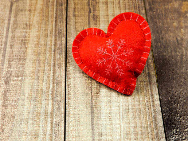 istock red and white heart with snowflake on wooden background, copy space 1047167646