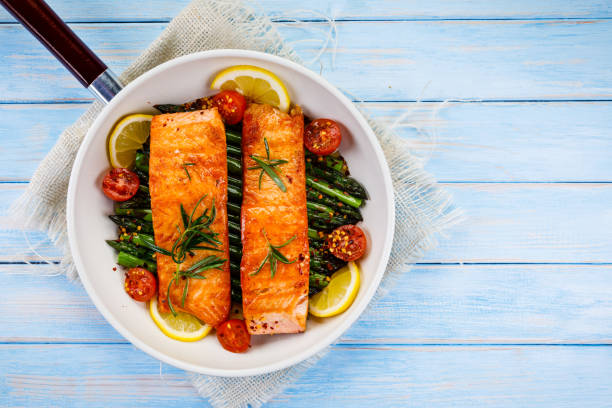 나무 테이블에 냄비에 야채와 아스파라거스 연어 구이 - salmon cooked pepper plank 뉴스 사진 이미지