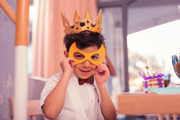 istock careful boy wearing yellow mask while being at the carnival 1047182878