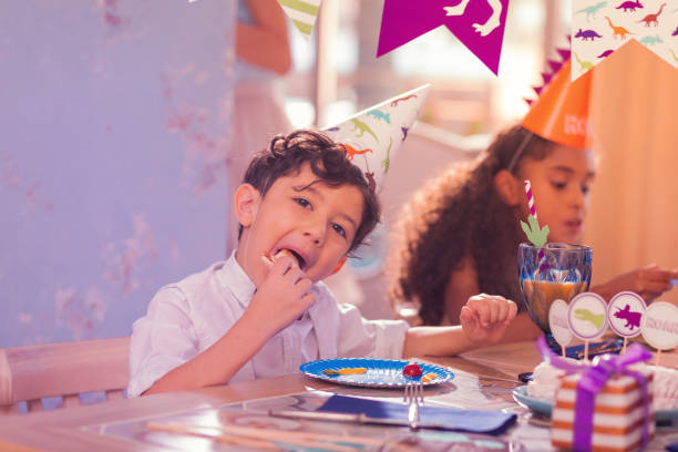 istock Hungry little boy looking glad while eating pizza 1047183020