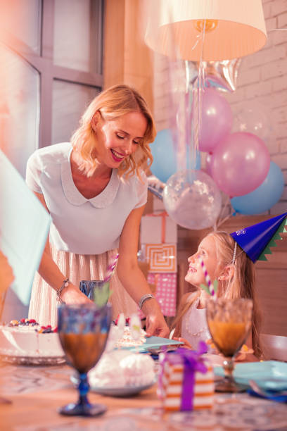 istock Cheerful mother smiling while putting cake on the plate 1047183060