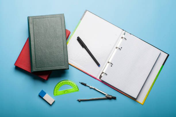 istock copybook, books, pen and ruler on blue background 1047184298