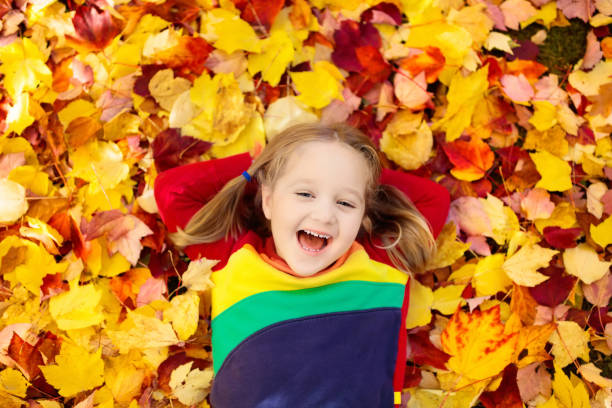 istock Child in fall park. Kid with autumn leaves. 1047193742