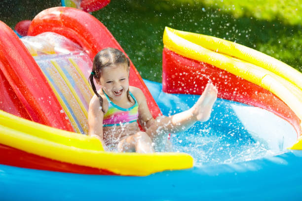 criança na piscina jardim com slide - inflatable slide sliding child - fotografias e filmes do acervo