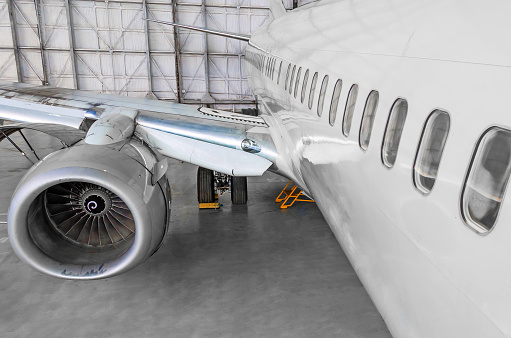 Passenger airplane on maintenance of jet engine and aircraft hangar