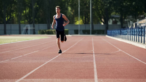 istock Man doing sports, running circles at stadium, daily workouts, active lifestyle 1047207726