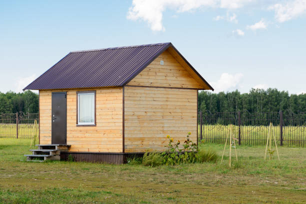 istock small wooden panel house on a green belt on a summer day 1047207934