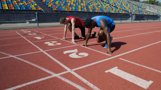 istock Two multiracial athletes in starting position, ready to run after command 1047209698