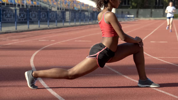 istock Female athlete doing gymnastics at stadium, warming up muscles for competition 1047210298