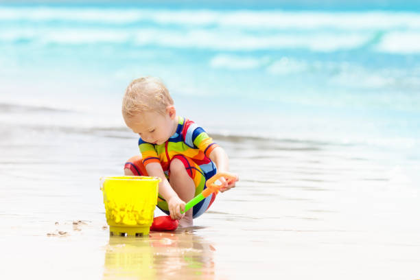 istock Kids play on tropical beach. Sand and water toy. 1047212828