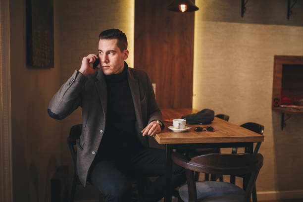 istock Serious businessman talking on a mobile phone at a cafe 1047213618