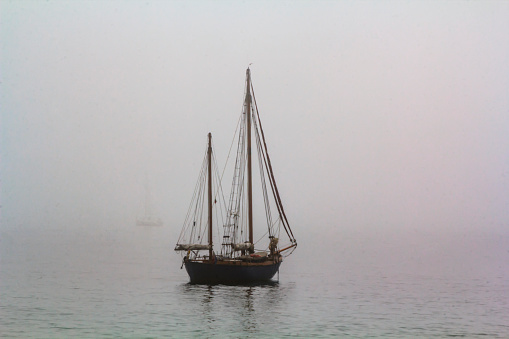 Tall ship sailing in the sea in foggy misty day