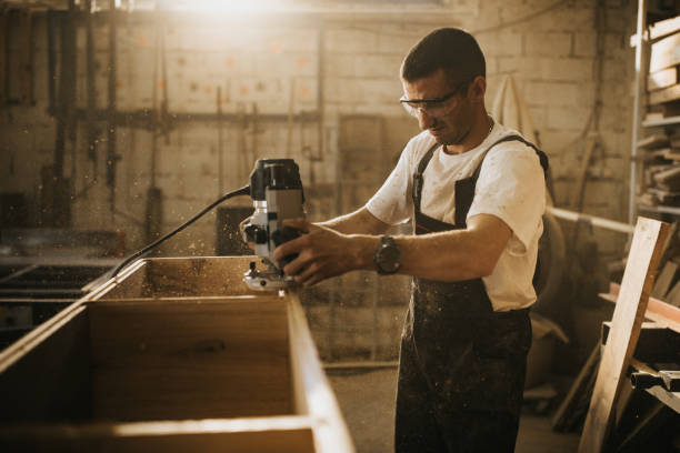 istock Young manual worker working with plane on a piece of wood in workshop. 1047233352