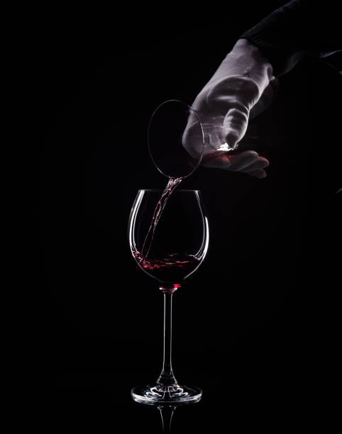 Hand pour red wine from decanter to glass