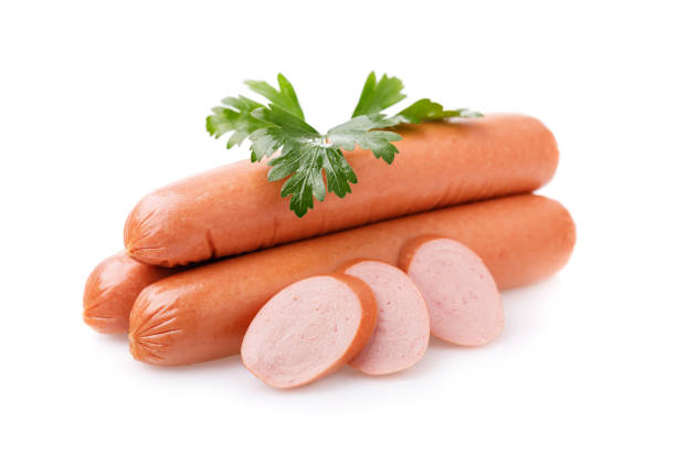 Three sausages with slices and fresh parsley isolated on white background stock photo