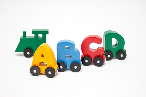 Letters A, B, C, D of a train alphabet with locomotive. Bright colors of red yellow green and blue on a white background. Early childhood development, learning to read and kids game concept