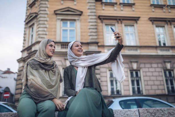 istock Beautiful Muslim university students doing a selfie outdoors 1047247056