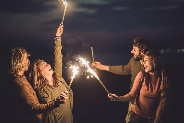 istock Two happy couples having fun with flaming torches by night. 1047279832