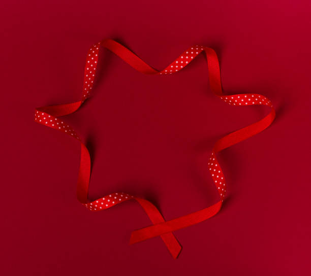 istock Wavy polka dot red ribbon on red background. 1047288610