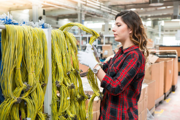 istock Young female working in cable factory 1047296736