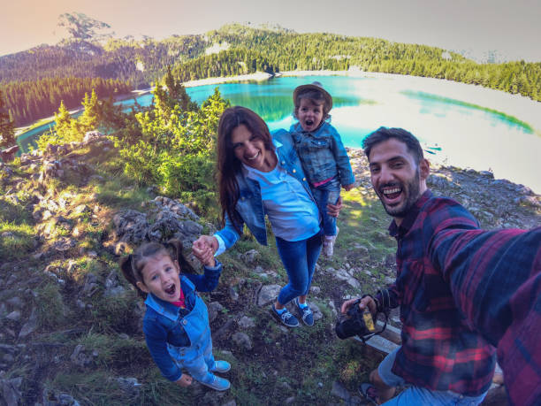istock Family on picnic in a forest taking selfie group portrait 1047296796