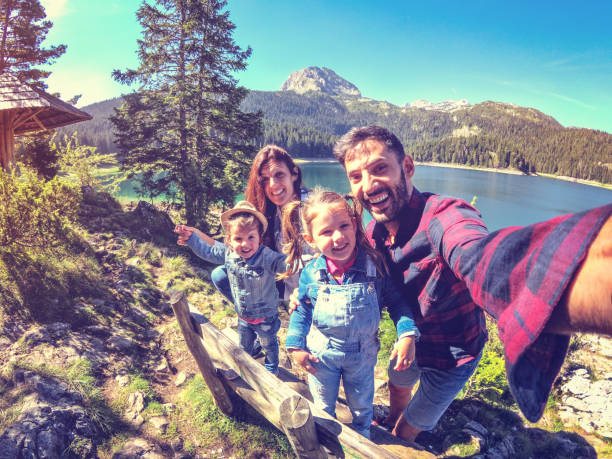 Family on picnic in a forest taking selfie group portrait