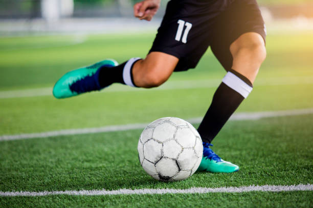 istock Soccer player speed run to shoot ball to goal on artificial turf. 1047304156