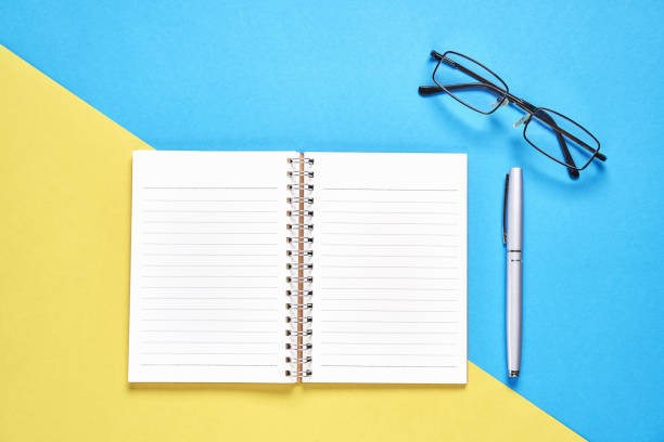 istock Black screen notebook blank and pen placed on pastel yellow and blue background. Suitable for graphics used for advertising. 1047311464