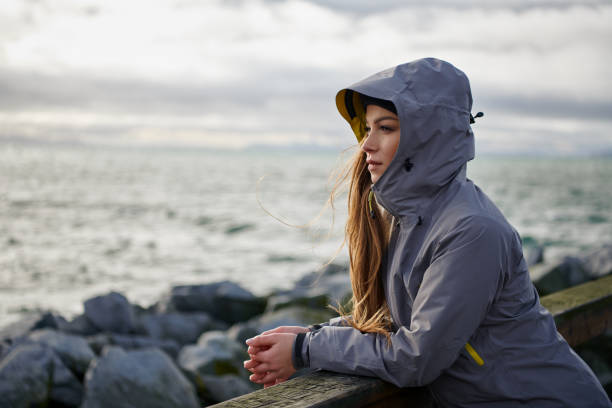 Young beautiful woman wearing rain jacket in cold weather Shoot of young beautiful woman wearing rain jacket in cold weather raining outside stock pictures, royalty-free photos & images